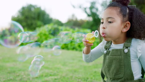 Happy-girl-kid-blowing-soap-bubbles-in-park