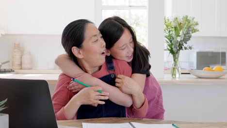 Hug,-child-and-mother-working-with-a-laptop