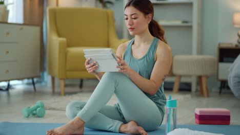 Yoga,-fitness-and-woman-browsing-tablet-for-online
