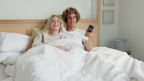 Couple-in-bed-watching-tv-in-bedroom