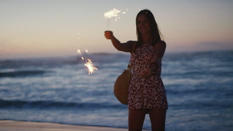 Woman,-happy-and-beach-with-sparklers-at-sunset