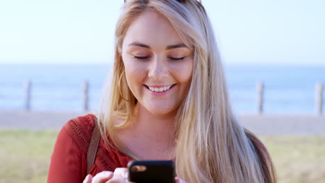 Woman,-face-or-laughing-at-phone-by-beach