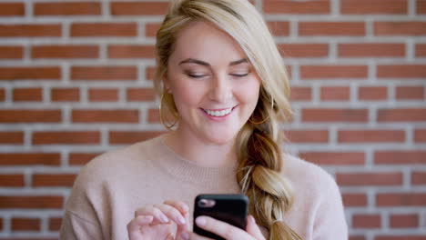 Woman,-phone-and-smile-or-typing-with-brick-wall