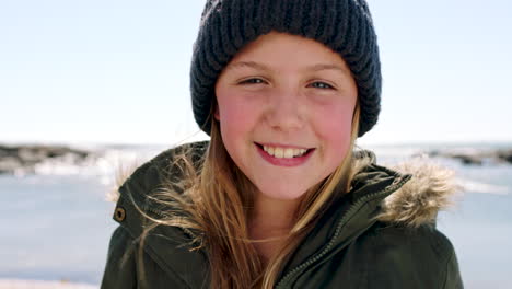 Child,-face-and-happy-girl-at-beach-with-winter