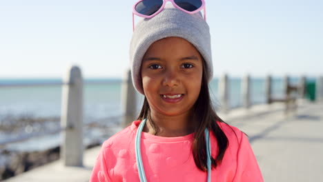 Child,-face-and-fashion-at-beach-promenade