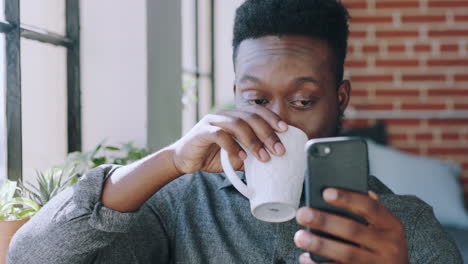 Phone,-coffee-and-black-man-relaxing-in-his-living