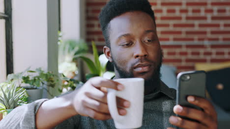 Black-man,-phone-and-drinking-coffee-by-apartment
