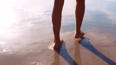 Woman-feet,-beach-sand-and-walking-in-water