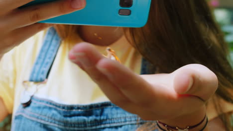Hand,-Schmetterling-Und-Mädchen-Mit-Smartphone