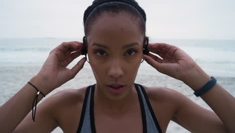 Woman-runner,-beach-and-face-with-headphones