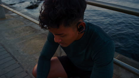 Rest,-beach-and-man-with-earphones-after-running