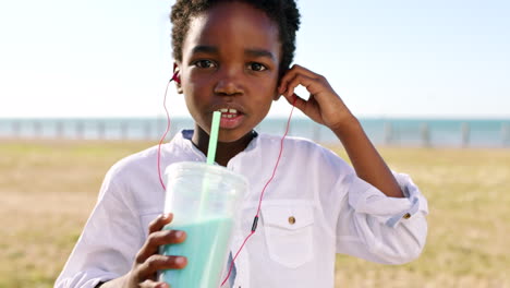 Child,-earphones-and-drinking-milkshake-outside