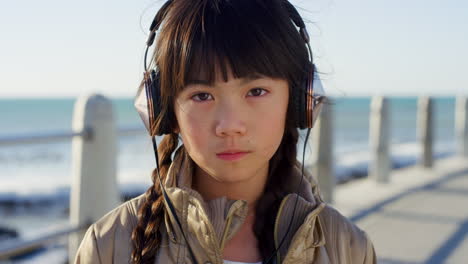 Girl-child,-face-and-headphones-at-beach