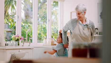 Senior-woman,-child-and-happy-dancing-in-kitchen