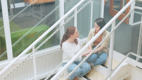 Friends,-women-sitting-on-stairs-at-apartment