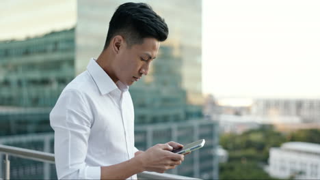 Asian-man,-city-business-and-phone-on-rooftop