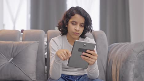 Indian-kid-using-and-scrolling-through-tablet