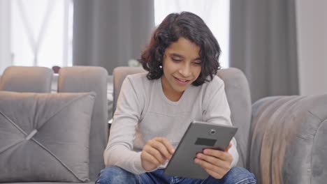 Happy-Indian-kid-boy-scrolling-through-tablet