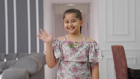 Happy-Indian-kid-girl-greeting-to-the-camera-by-waving-Hello