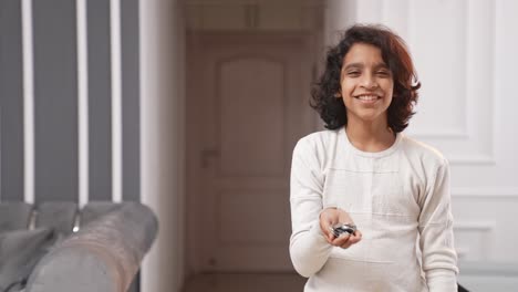 Indian-kid-holding-coins-in-hand-and-pointing-left-for-copyspace