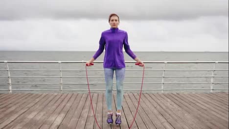 Young-woman-working-out-on-the-jump-rope.-Outdoor-sports.-Girl-jumping-on-a-skipping-rope-by-the-sea.-Slow-Motion-shot