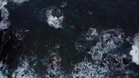Timelapse.-Aerial-top-view-waves-break-on-rocks-in-a-blue-ocean.-Sea-waves-on-beautiful-beach-aerial-view-drone-shot.-Ocean