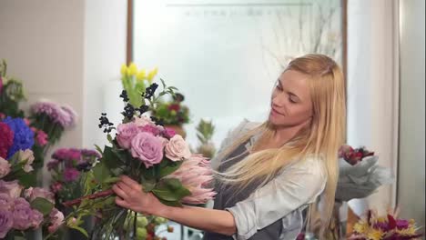 Young-female-florist-arranging-modern-bouquet,-young-handsome-florists-work-at-flowers-shot-making-bouquet.-Slow-Motion-shot