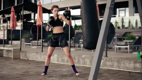 Starke-Athletische-Boxerin-In-Handschuhen,-Die-Mit-Einer-Tasche-Trainiert.-Training-Draußen.-Boxertraining-Für-Frauen.-Selbstverteidigungskonzept