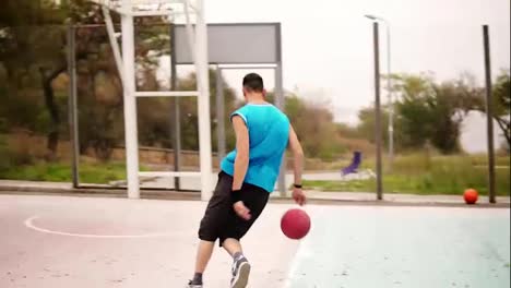 Tracking-shot-of-a-young-man-running-with-a-ball-and-throwing-a-ball-to-the-basket-successfully.-Basketball-game.-Slow-Motion