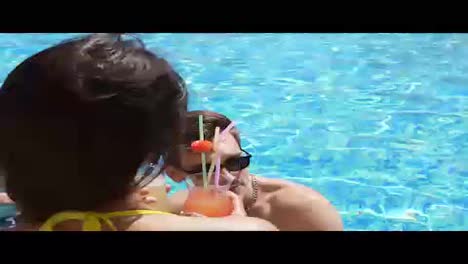 Young-adult-couple-flirting-and-talking-in-the-swimming-pool.-Summertime-pool-party.-Slow-Motion-shot