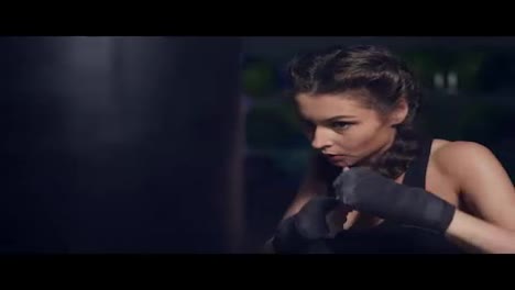 Close-Up-view-of-a-young-woman-punching-a-boxing-bag-with-her-hands-wrapped-in-boxing-tapes.-Boxing-in-Slow-Motion