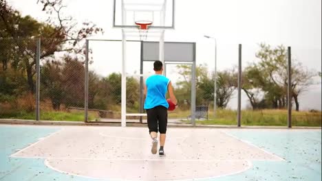 Rückansicht-Eines-Jungen-Mannes,-Der-Basketball-Spielt-Und-Erfolgreich-Einen-Ball-In-Den-Korb-Wirft.-Zeitlupenaufnahme