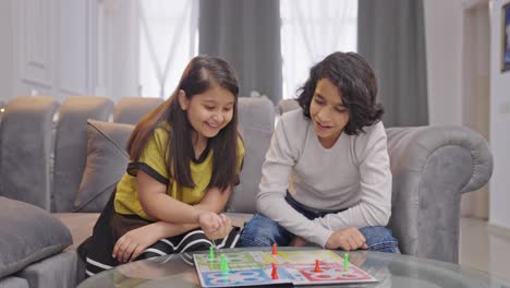 Happy-Indian-siblings-playing-Ludo-board-game-with-dice