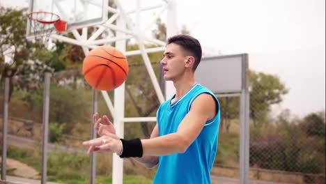 Portrait-of-a-Basketball-player-spinning-a-basketball-on-the-street-playground.-Slow-Motion-shot