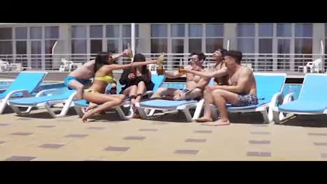 Group-of-beautiful-young-people-drinking-cocktails-and-having-fun-at-the-swimming-pool.-Slow-Motion-shot