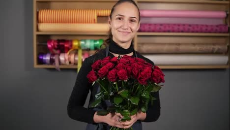 Perfect-bouquet-of-red-roses-from-professional-florist:-young-attractive-female-florist-holding-a-bouquet-of-beautiful-red-roses