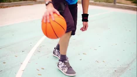 Close-up-view-of-a-young-man-practicing-basketball-outside.-Slow-Motion-shot