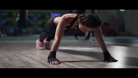 Junge-Frau-Macht-Plankenübungen-Im-Fitnessstudio.-Fitness-Frau-Beim-Planken-Mit-In-Boxbändern-Gehüllten-Händen-Und-Beim-Training-Des-Körpergewichts