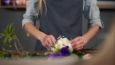 Nahaufnahme-Der-Hände-Einer-Blumenfotografin,-Die-Einen-Auf-Ihrem-Tisch-Liegenden-Blumenstrauß-Mit-Dem-Band-Bindet.-Zeitlupenaufnahme