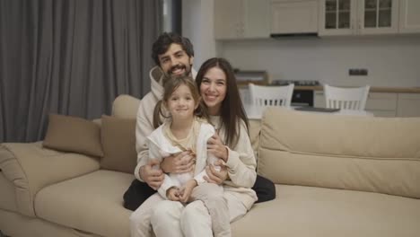 Portrait-of-a-happy-family-of-three,-mom,-dad-and-daughter-make-a-family-photo-at-home
