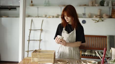Red-haired-potter-girl-puts-her-products-in-a-wooden-box