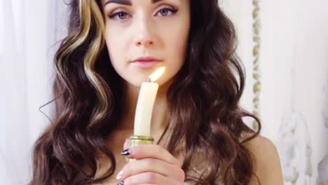 Young-brunette-woman-snuffs-off-a-candle
