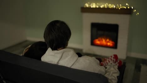 Couple-sitting-at-home-by-the-fireplace-embraced