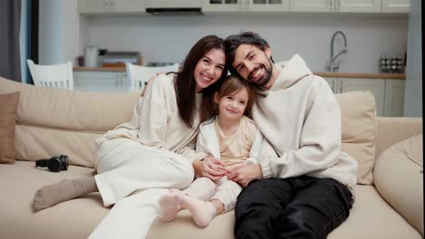 Happy-family-of-three,-mom,-dad-and-daughter-make-a-family-photo-at-home
