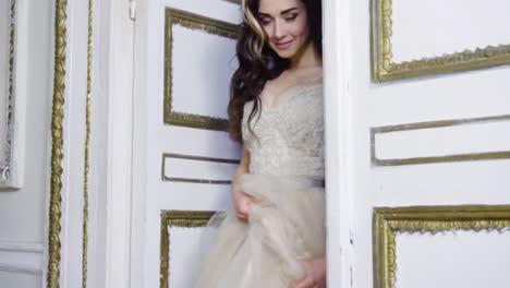 Young-brunette-woman-in-long-evening-dress-comes-out-of-the-door