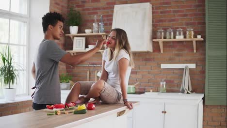 Slow-Motion-shot-of-attractive-multi-ethnic-couple-chatting-in-the-kitchen-early-in-the-morning.-Handsome-man-feeding-his