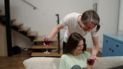 Handsome-man-bringing-glasses-of-wine-to-wife-in-slow-motion