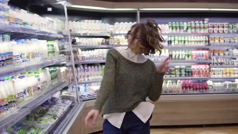Young-woman-dancing-through-grocery-store-aisles.-Excited-woman-having-fun,-dancing-supermarket.-Slow-motion