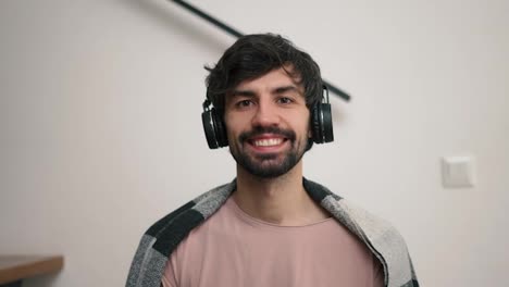 Smiling-bearded-man-with-headphones-looking-to-the-camera