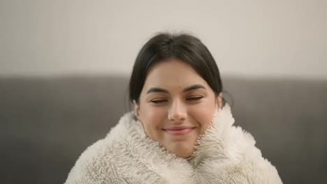 Young-beautiful-woman-in-warm-blanket-at-home